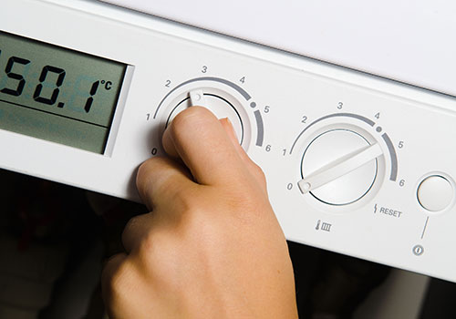 Photo of an engineer adjusting a thermostat